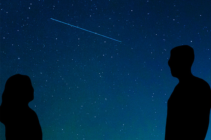 Silhouettes of a man and woman facing each other on a starry sky